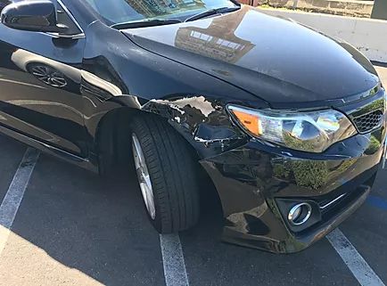 Black sedan with front-end damage, before repair